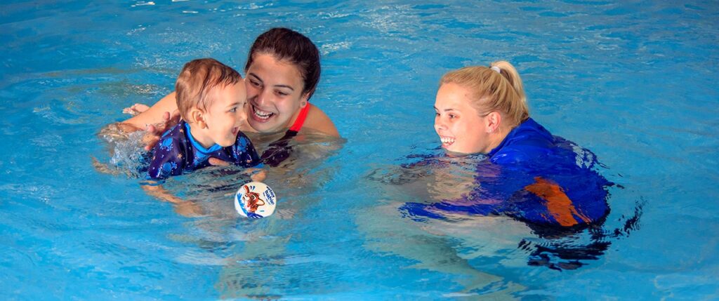 baby swimming with parent and water babies teacher