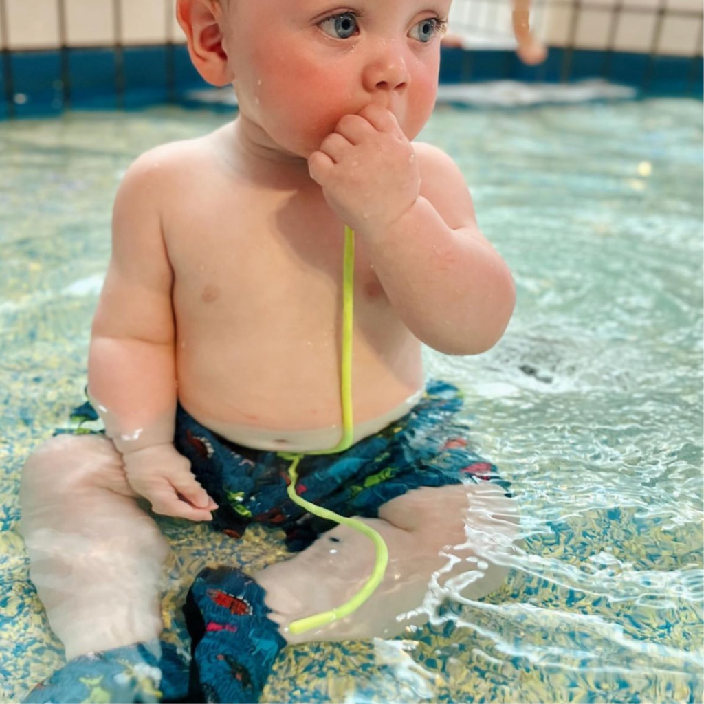 baby sat in swimming pool with slipfree shoes on