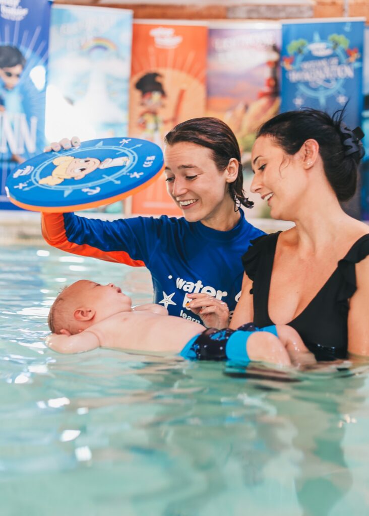 water babies teacher with baby on their back and a splash mirror
