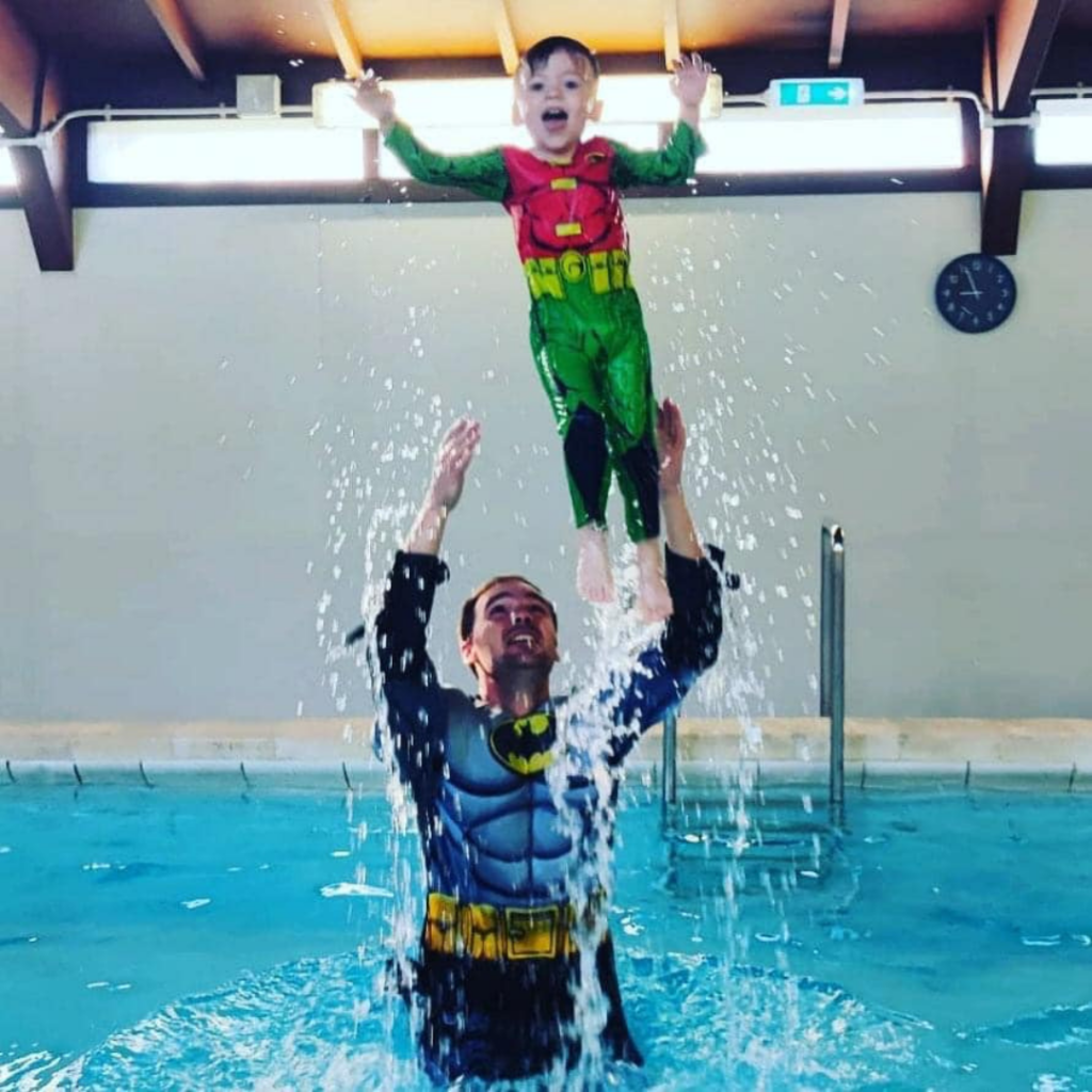 father and son splashing in the pool