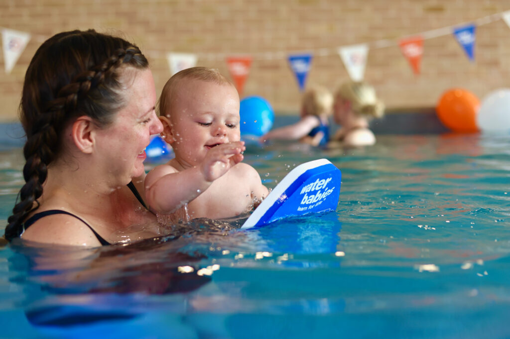 carer and baby in the pool at water babies 20th birthday