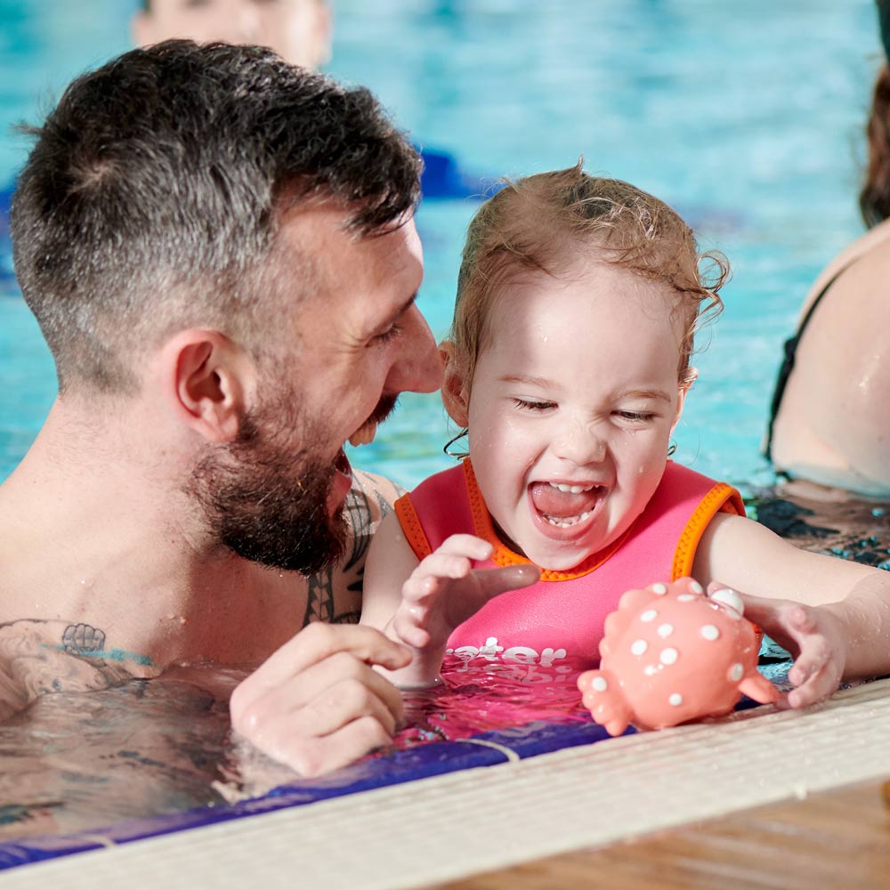dad and daughter in the pool at water babies lessons
